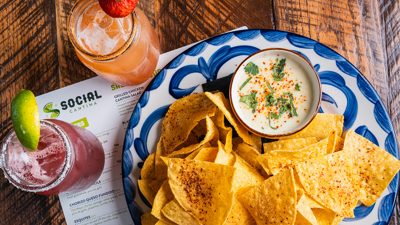 Chips with white queso and two margaritas on a table at Social Cantina in Germantown, Nashville